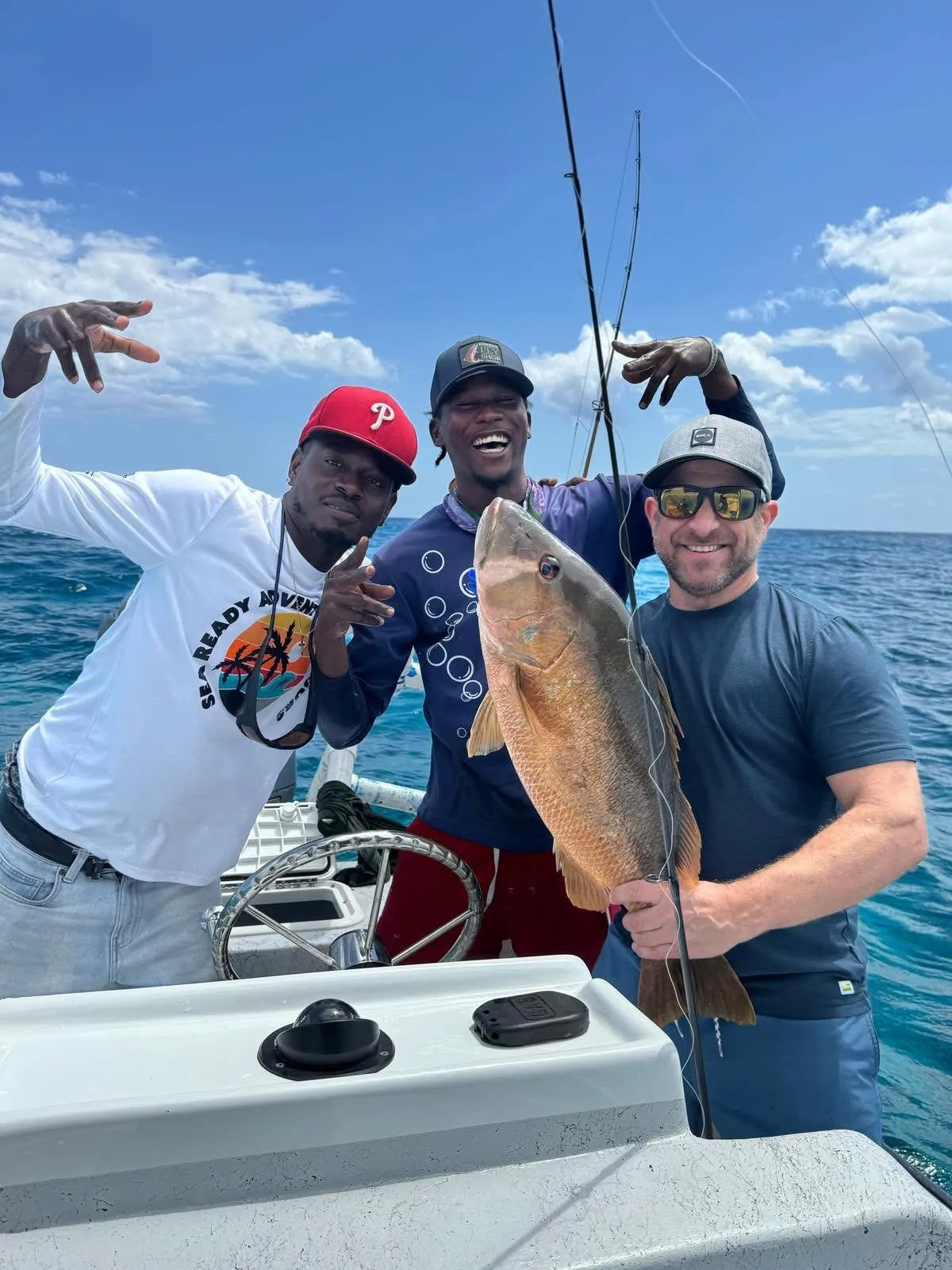 Crew and guest celebrating a big mutton snapper on the boat